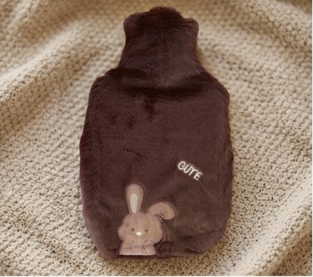 hot water bottle covers in brown, with a bunny face detail and small white text. 