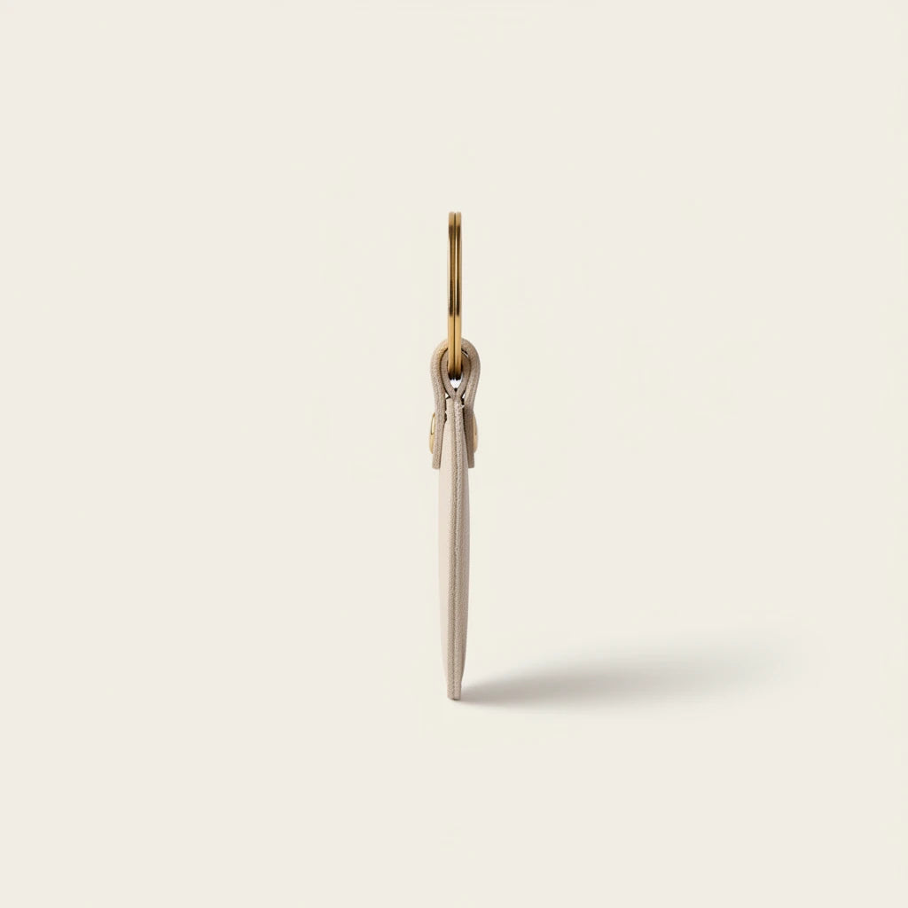 Campus Zone beige heart-shaped vegan leather keychain with gold-tone ring, shown from a slim side profile view.