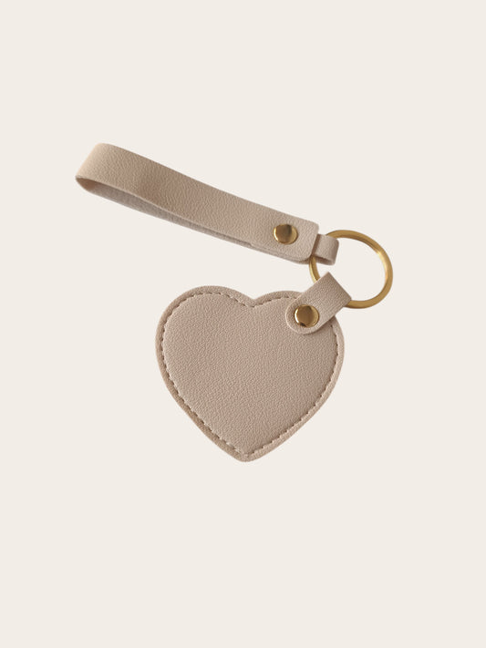 Campus Zone beige vegan leather heart-shaped keychain with a wristlet strap and polished gold-tone hardware.