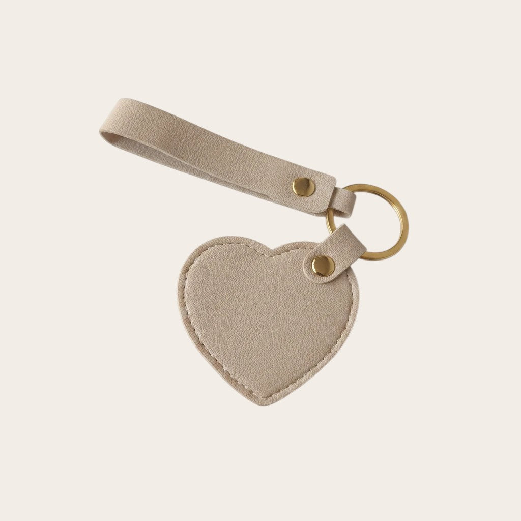 Campus Zone beige vegan leather heart-shaped keychain with a wristlet strap and polished gold-tone hardware.