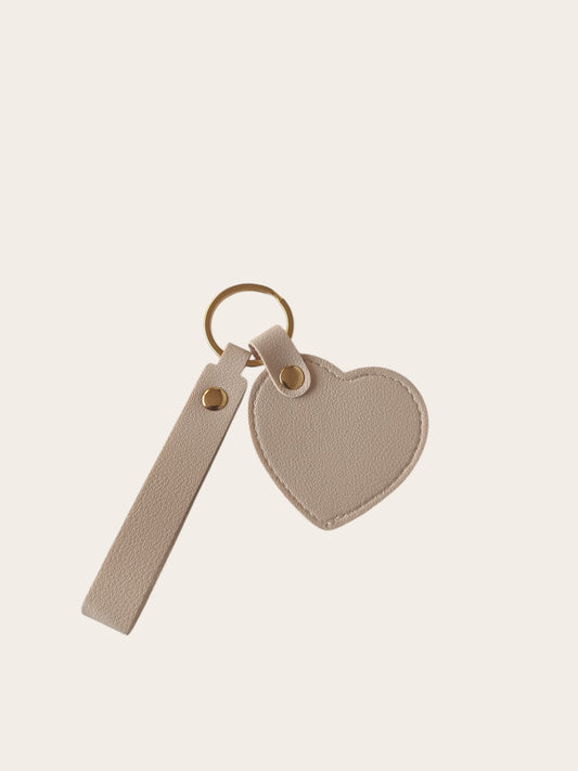 Campus Zone beige vegan leather heart-shaped keychain with a wristlet strap and polished gold-tone hardware.