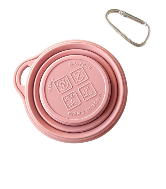 Campus Zone pink collapsible silicone travel cup folded flat with a metal keychain clip on a white background